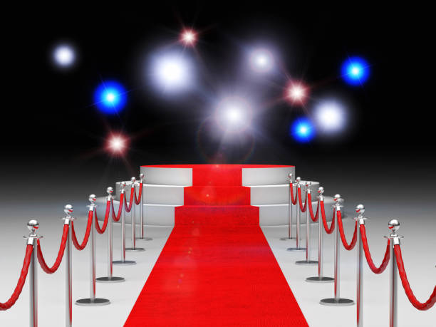 istock Red Carpet Amidst Bollards Against Illuminated Lights 1129714167