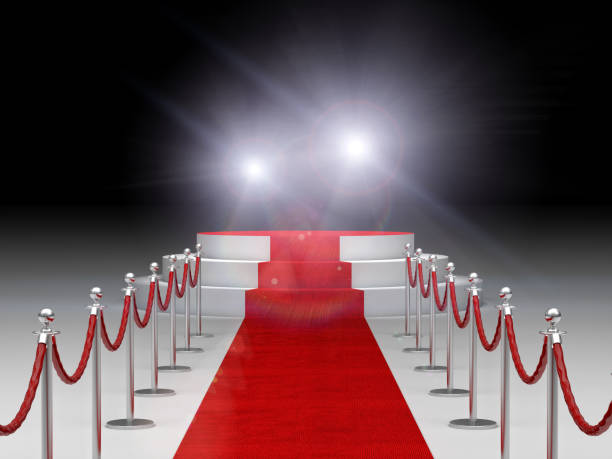 istock Red Carpet Amidst Bollards Against Illuminated Lights 1129714173