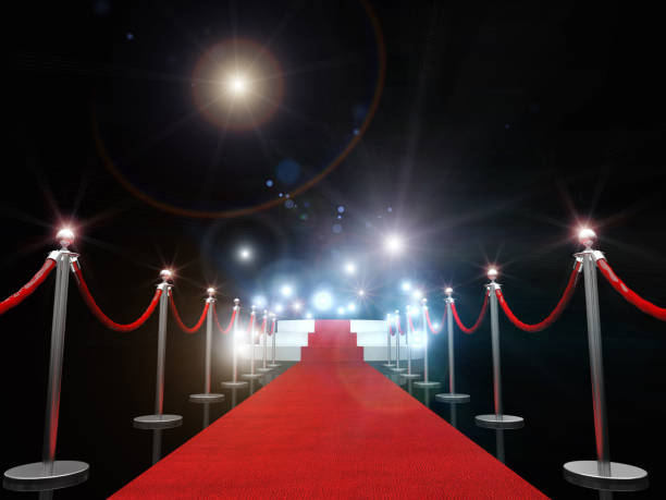istock Red Carpet Amidst Bollards Against Illuminated Lights 1129714181