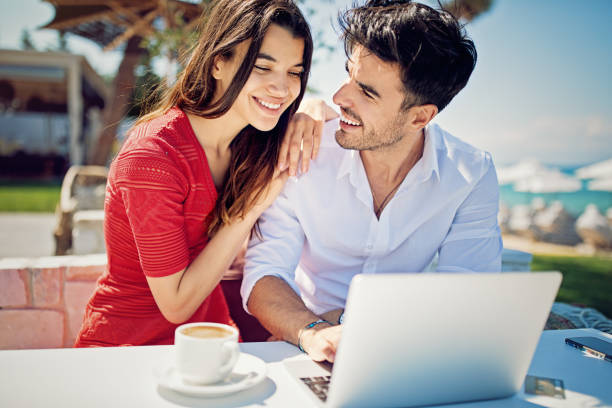 istock Couple is hugging and browsing on the beach 1129715080