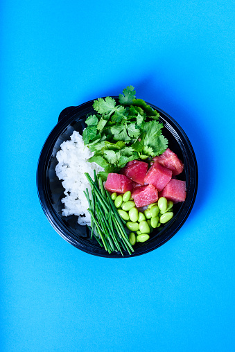 Hawaiian poke bowl with tuna and edamame. Ready-to-eat, to go fast food. Healthy ingredients. Top view, flat lay.