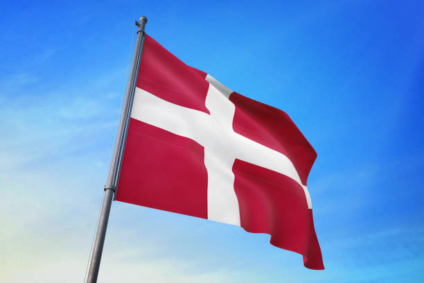 istock Denmark flag waving in the blue sky 1129718222