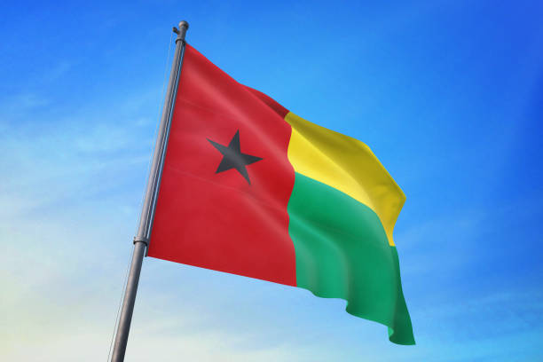 guinea-bissau-fähnchen in den blauen himmel - guinea bissau flag stock-fotos und bilder