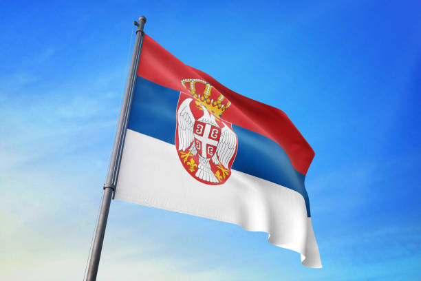 istock Serbia flag waving in the blue sky 1129720125