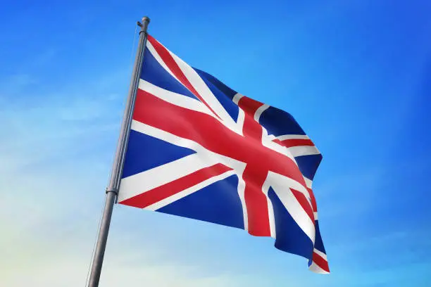 Photo of United Kingdom flag waving in the blue sky