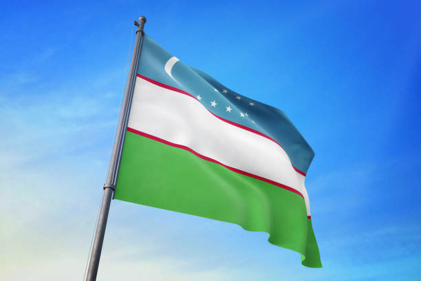 istock Uzbekistan flag waving in the blue sky 1129720434