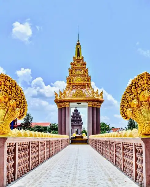 Golden Independence monument, Naga bridge walk way through the monument with beautiful clouds and blue sky background, Ta Keo, Cambodia