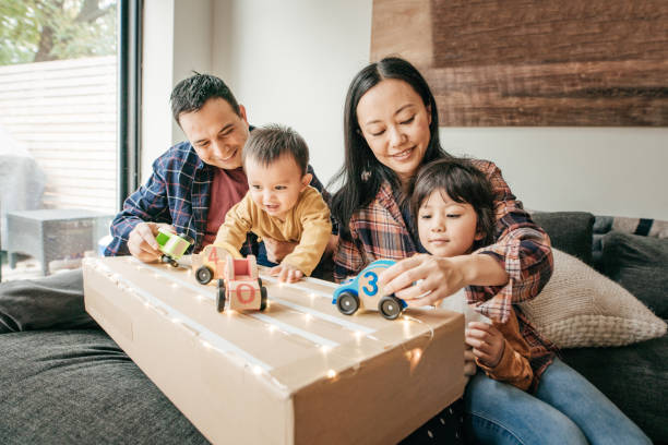 cosy family evening with kids and parents - asian and indian ethnicities imagens e fotografias de stock