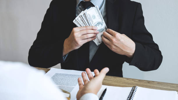 istock Businessman Receiving Bribe At Desk In Office 1129732215