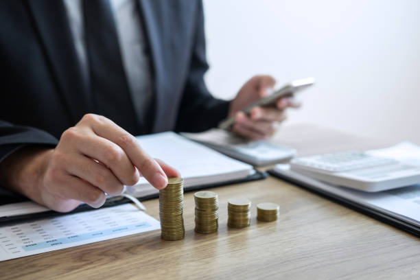 istock Midsection Of Man Businessman Stacking Coins On Desk 1129732220