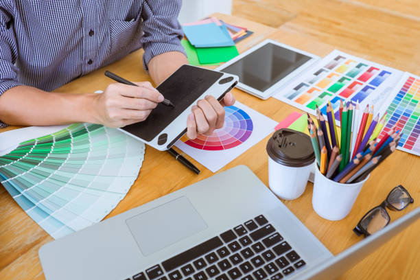 istock Midsection Of Man Using Graphics Tablet At Desk In Office 1129733575