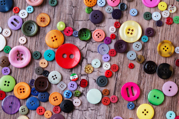 botões de costura sortidas coloridas em uma tabela - various sizes - fotografias e filmes do acervo
