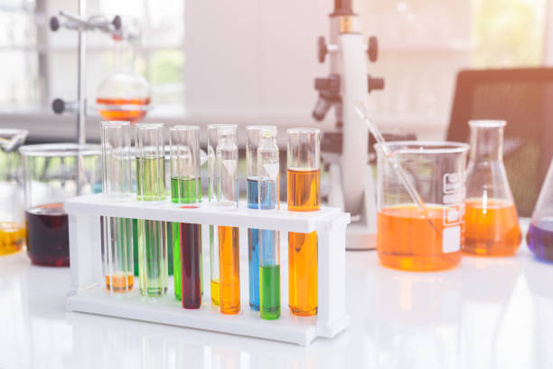 istock Test tubes with colorful liquids in holder on table in laboratory. 1129737041
