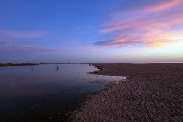 istock Pink sunset cloud reflection over Santa Clara river seaside marsh at Ventura beach in California United States 1129737626
