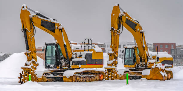 istock Excavators against snow and buildings in Daybreak 1129741621