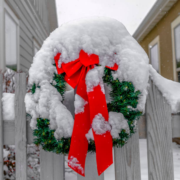 istock Snow covered wreath on white picket fence in Utah 1129745446