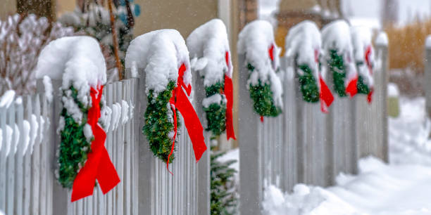 istock White fence lined with Christmas wreaths in Utah 1129745517