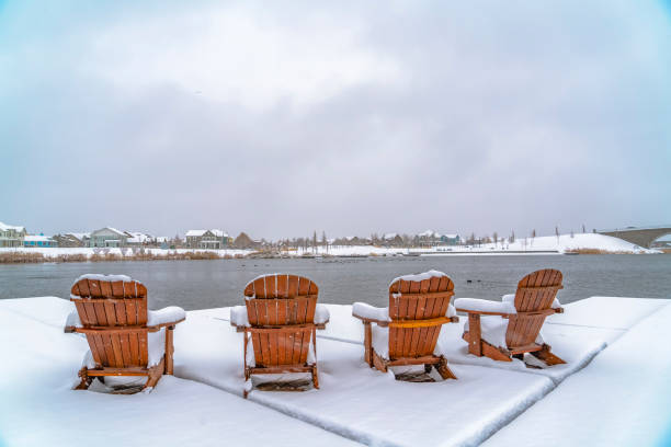 istock Wooden chairs on deck overlooking lake and homes 1129745530