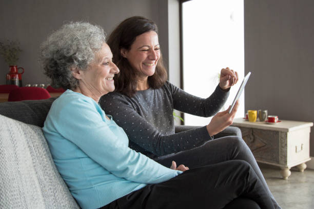 istock Happy elderly woman and her daughter browsing on tablet computer 1129748611