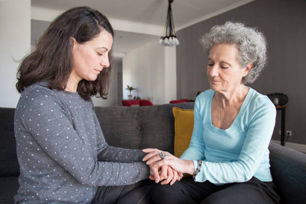 istock Serious senior woman and her daughter holding hands 1129748675