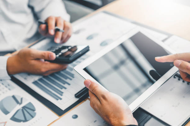Co-working Business Team Consulting meeting Planning with digital tablet Strategy Analysis investment and saving concept. meeting discussing new plan financial graph data.