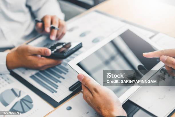 Coworking Business Team Consulting Meeting Planning With Digital Tablet Strategy Analysis Investment And Saving Concept Meeting Discussing New Plan Financial Graph Data Stock Photo - Download Image Now