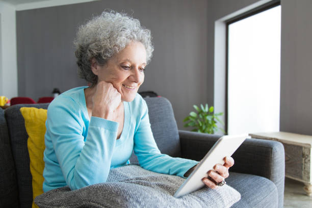 istock Content mature woman reading book on tablet 1129752810