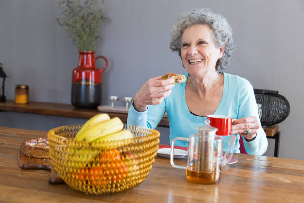 istock Happy senior lady enjoying dessert 1129752833