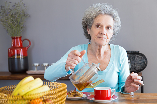 Sad Making Tea Sad Serious Senior Woman Pouring Herbal Tea For Herself Stock Photo ...
