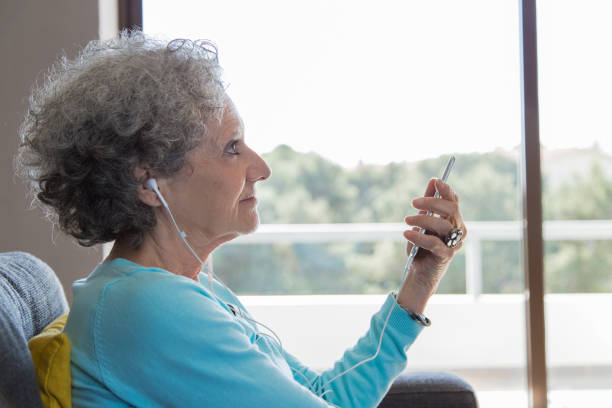 istock Side view of positive grey haired lady using smartphone 1129752884