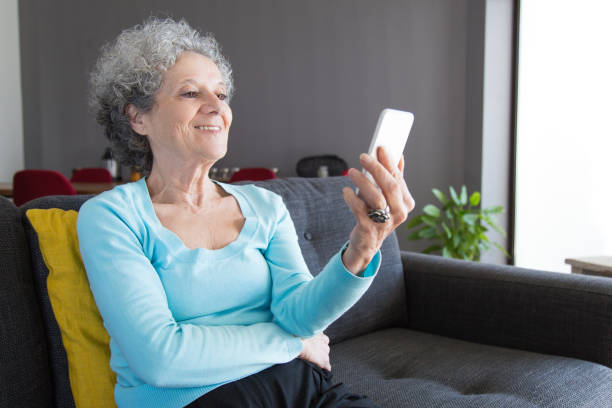 istock Positive retired woman using phone for video call 1129752894