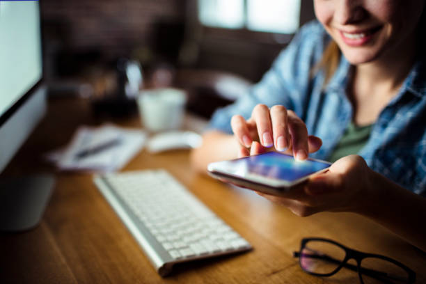 Woman using a Phone Close up of a young woman using a phone while working click link stock pictures, royalty-free photos & images