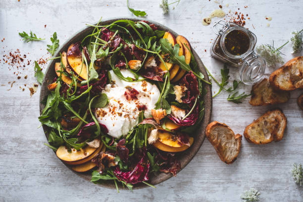 Peach Salad, Burrata Cheese, Arugula, Lettuce and Toast Peach Salad, Burrata Cheese, Arugula, Lettuce and Toast grillade stock pictures, royalty-free photos & images