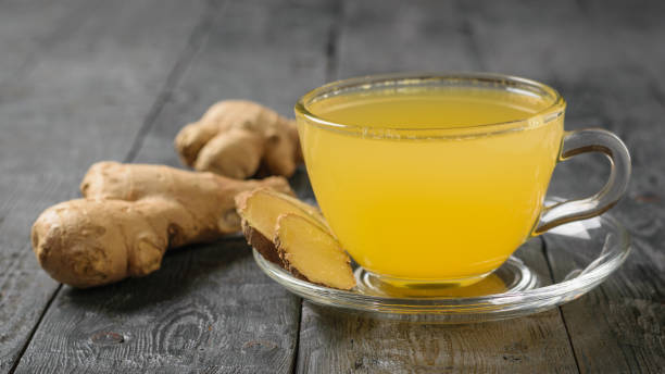 istock Drink and ginger and citrus and ginger root on a black wood table. 1129764298