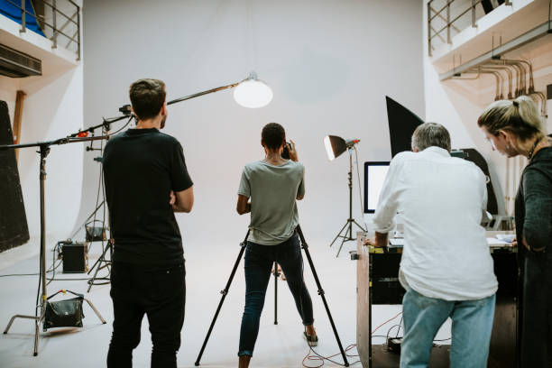 equipaggio che lavora insieme in studio - servizio fotografico foto e immagini stock