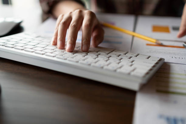 istock An auditor using a calculator for calculating with financial report and  typing on modern computer keyboard at office. Accounting and technology in office. Finance concept. 1129766384