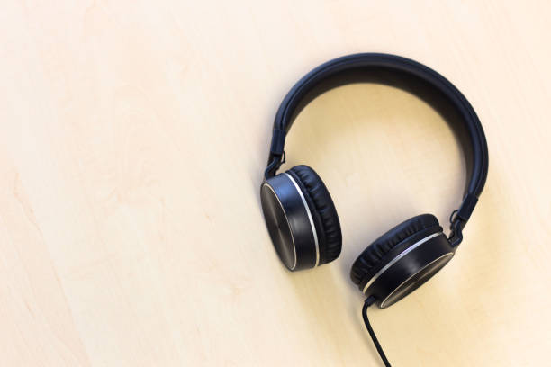 istock Black headphones on wooden table background 1129769047