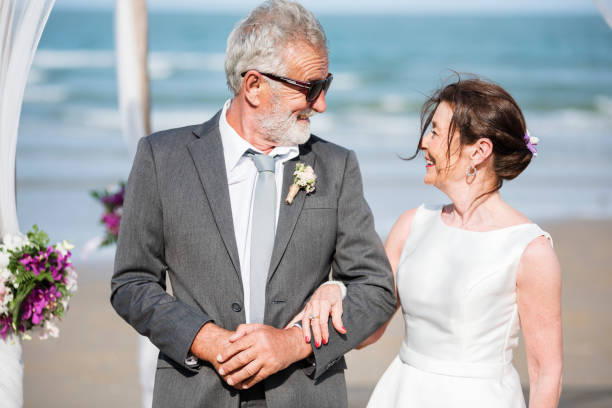 istock Senior couple getting married at the beach 1129770045