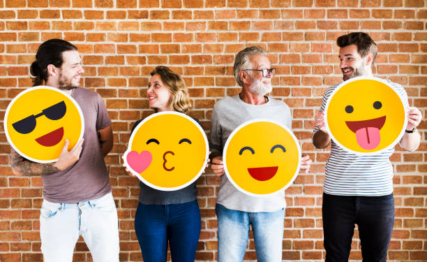 istock Happy people holding positive emoticons 1129770099