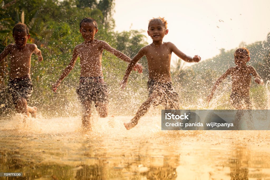 Asia children on river / The boy friend happy funny playing running in the water in countryside of living life kids farmer rural people Indonesia Stock Photo