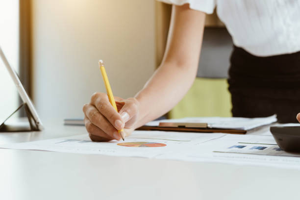 istock Businesswoman working with financial data and using calculator and writing make note with calculate. Business financial and accounting concept. 1129774364