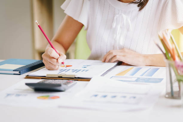istock Business woman working with new startup project discussion and analysis data financial report. Using a calculator to calculate numbers. Business financial and accounting concept 1129774936
