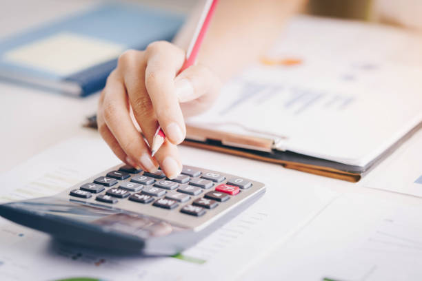 istock Close up of bookkeeper or financial inspector hands making report, calculating or checking balance. Investment, economy, saving money or insurance concept 1129774968