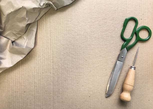 istock an awl with a wooden handle and scissors on kraft cardboard. 1129775168
