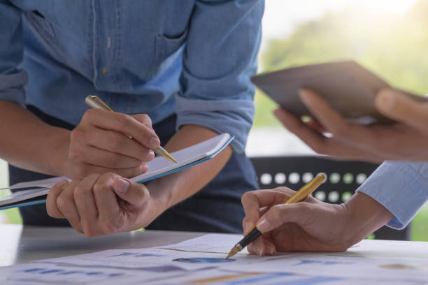 istock Business meeting time. Discussing a financial plan with financial document graph in meeting room. Young account working with new startup project. Business concept. 1129779528