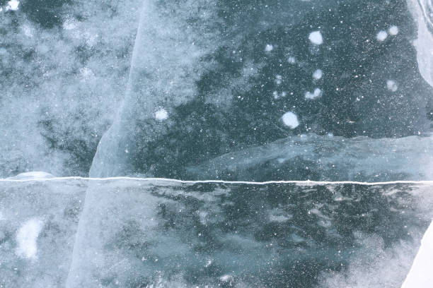 istock Ice on the frozen road surface across the river, natural background 1129780578