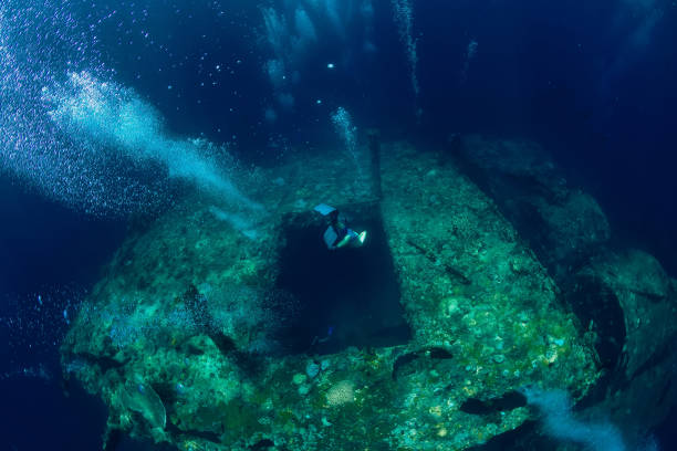istock Free diver man dive to shipwreck in ocean, underwater 1129781768