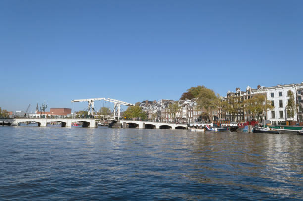 cityscape of Amsterdam from river Amstel with white drawbridge