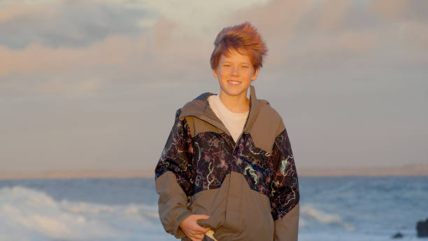 Portrait of boy at sunset. Ocean on background.