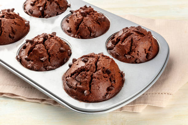 muffin al cioccolato in una padella su sfondo chiaro con spazio di copia - vegan food cake muffin chocolate foto e immagini stock